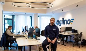 Petar Vukasinovic, Founder and CEO at Agilno, sitting in the office. In the background developers working, Agilno logo on the wall.